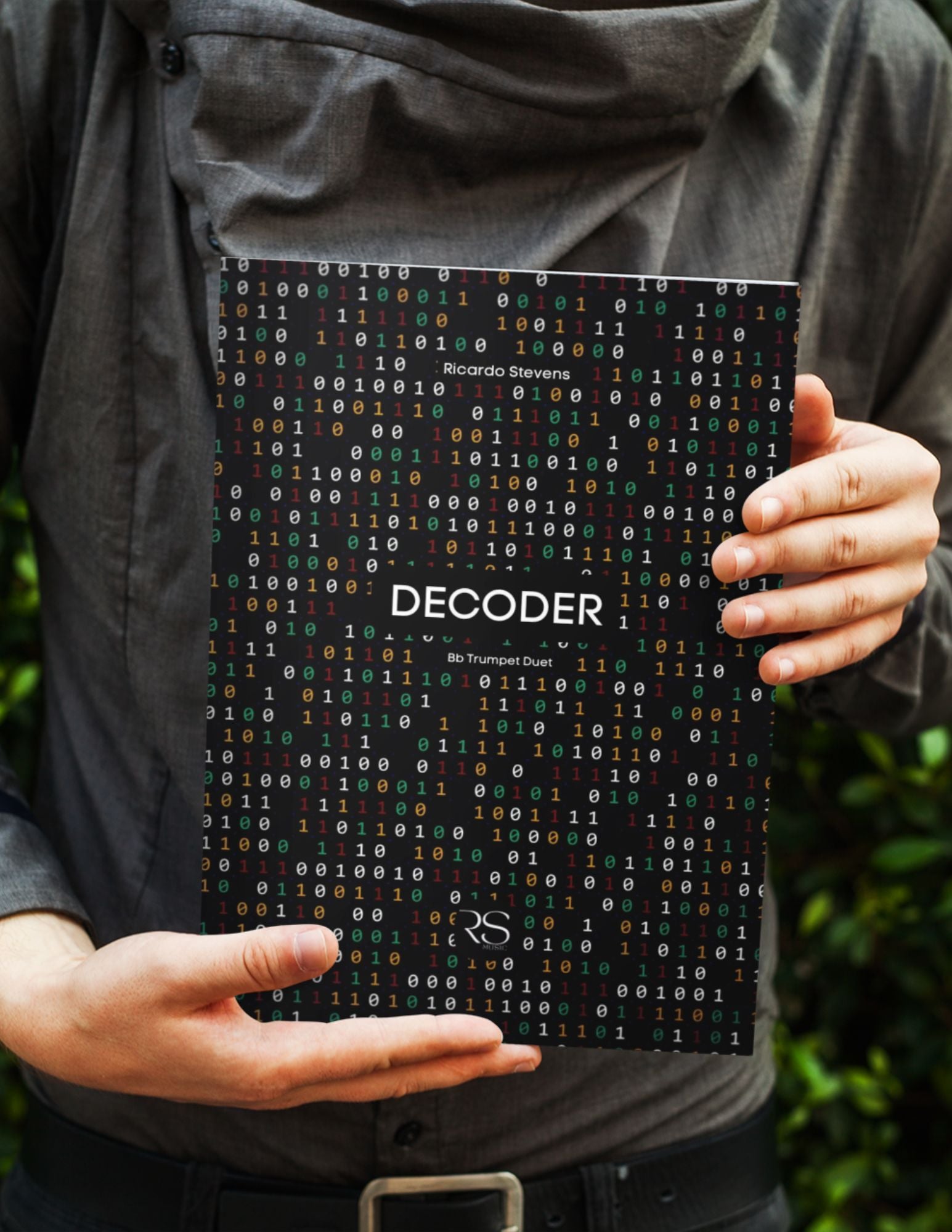 Person holding a book titled 'Decoder' with a black cover featuring white text by Ricardo Stevens.