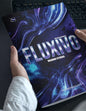 Book titled 'FLUXIVO' by Ricardo Stevens held by a person with a keyboard in the background